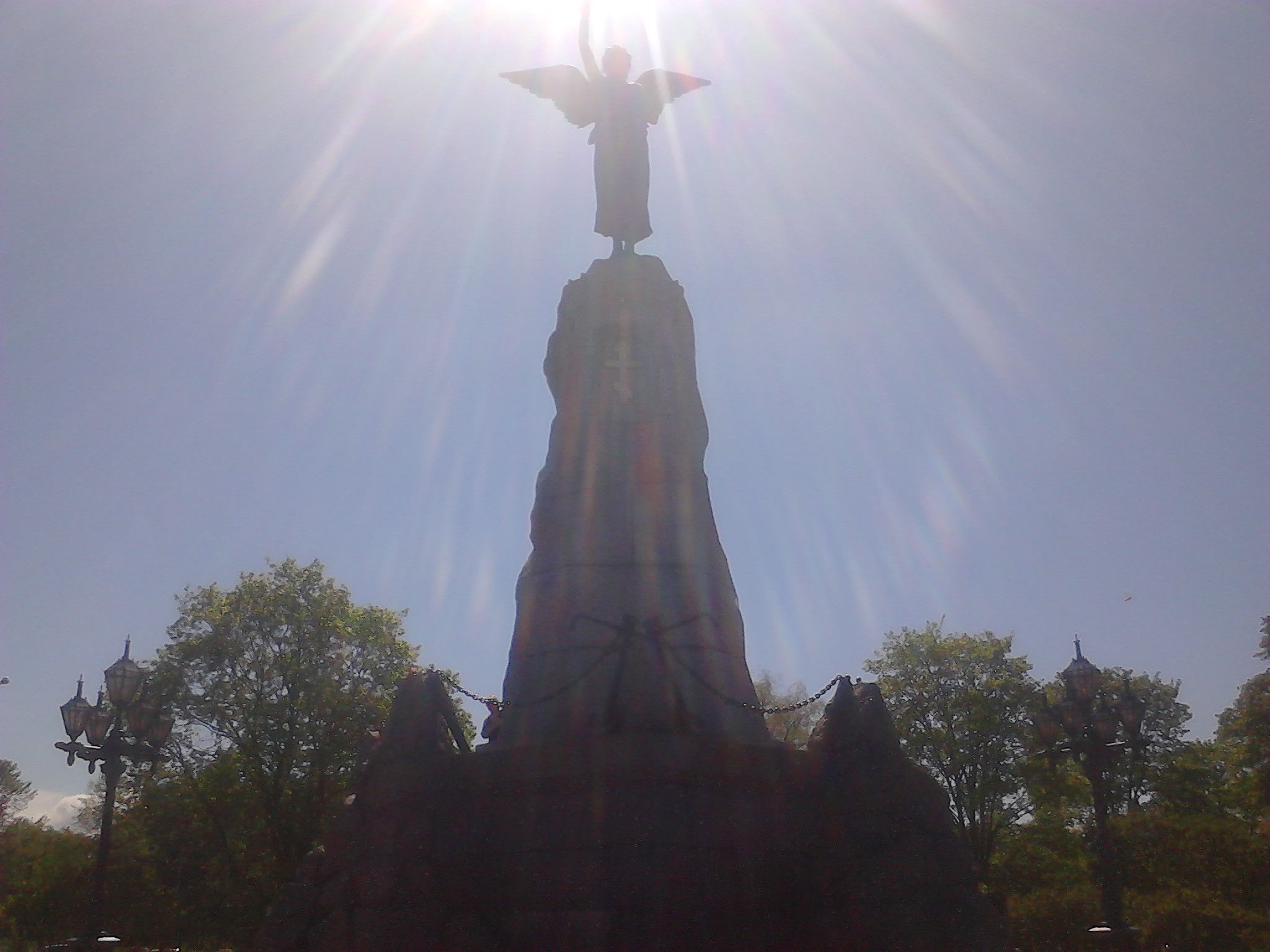 A monument of a woman with wings. It looks from the angle as if the statue is golding the sun in her hand